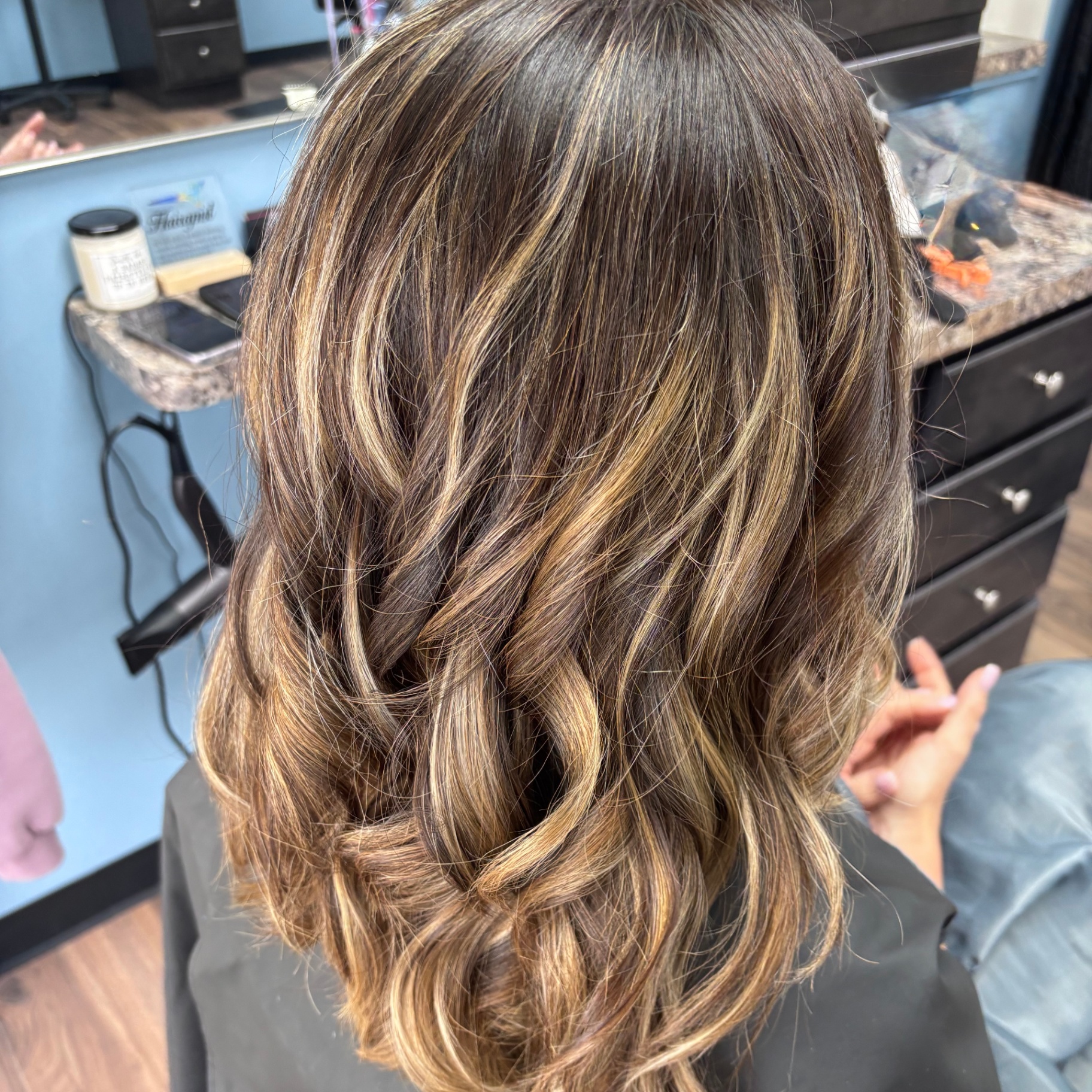 Caramel highlighted wavy brunette at Favero's Hair Salon