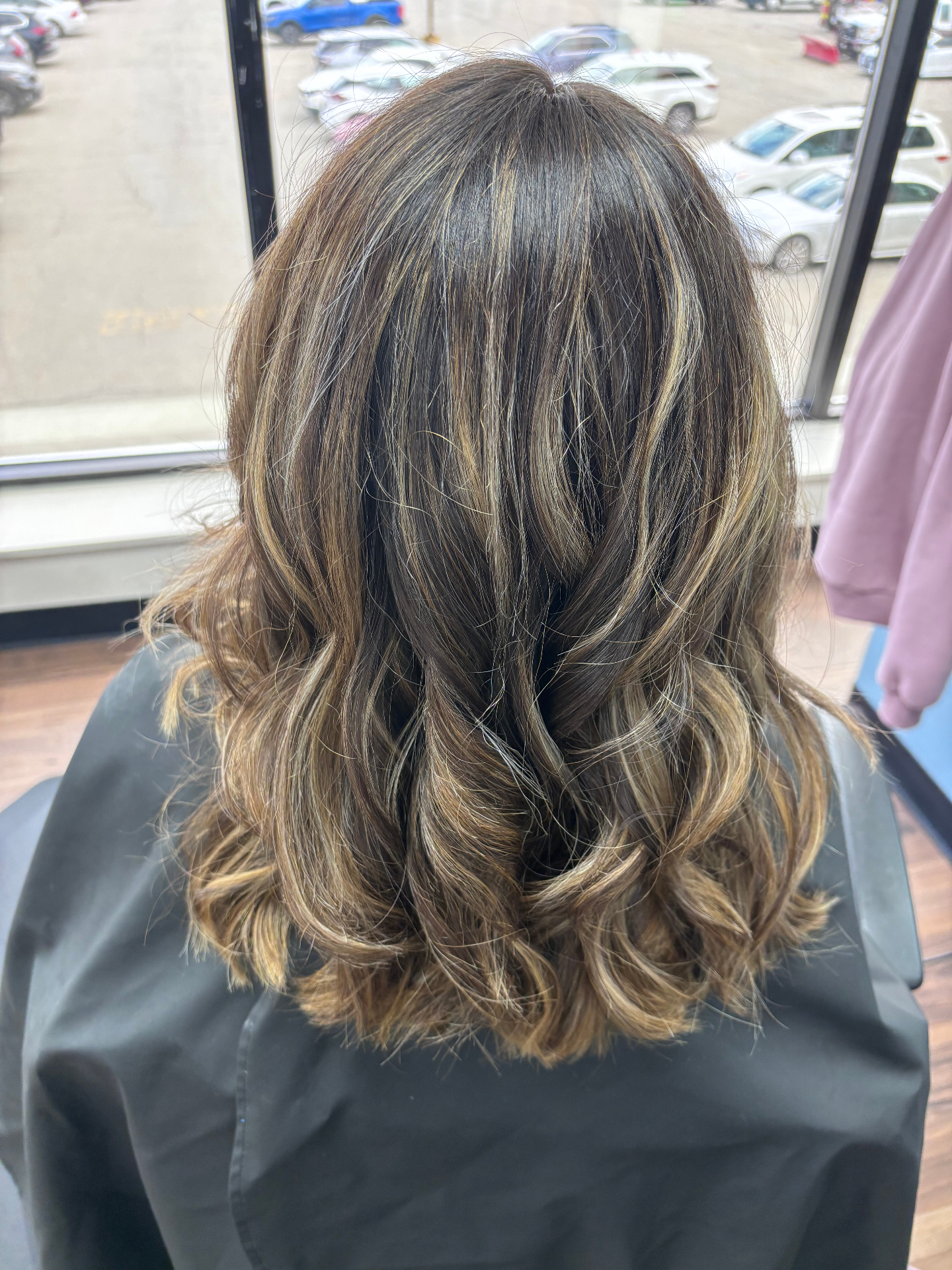 Dimensional brunette balayage with soft curls at Favero's Hair Salon