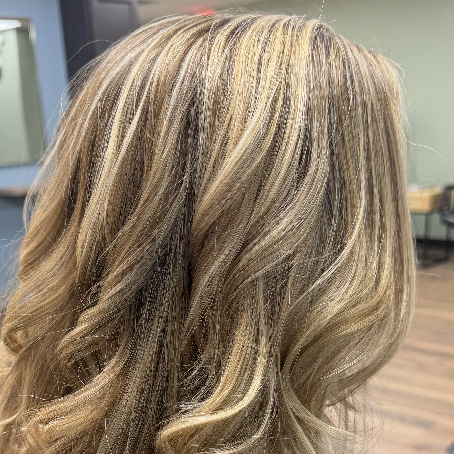 Sandy blonde highlights with soft waves at Favero's Hair Salon